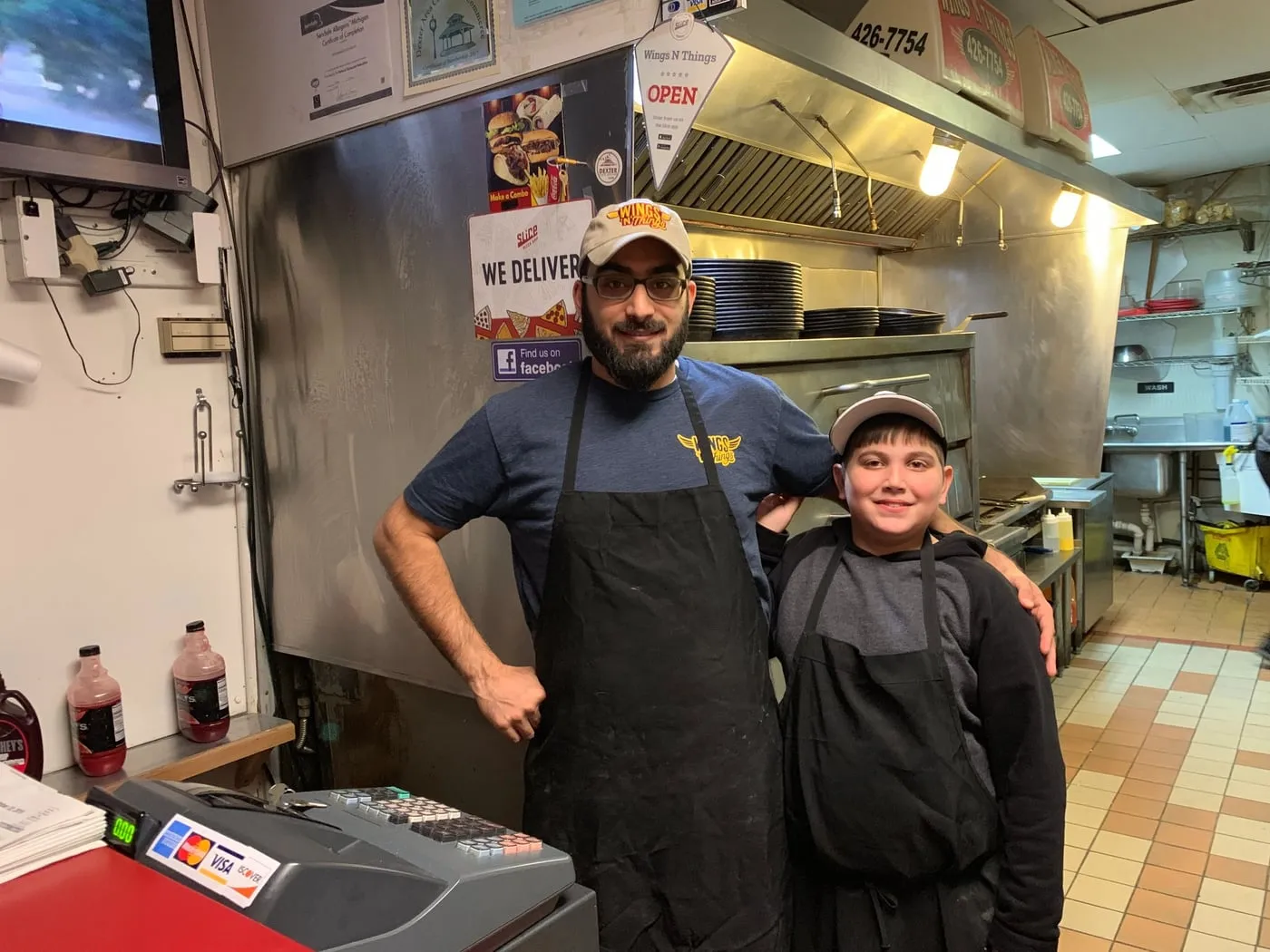 Two of the crew in aprons, side by side at the counter
